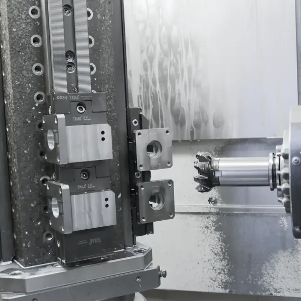 Nahaufnahme einer CNC-Fräsmaschine bei der Bearbeitung eines metallischen Werkstücks, wobei Metallspäne auf dem Maschinenbett zu sehen sind. Das Schneidwerkzeug ist in der Nähe des Werkstücks positioniert, bereit für die Präzisionsbearbeitung.
