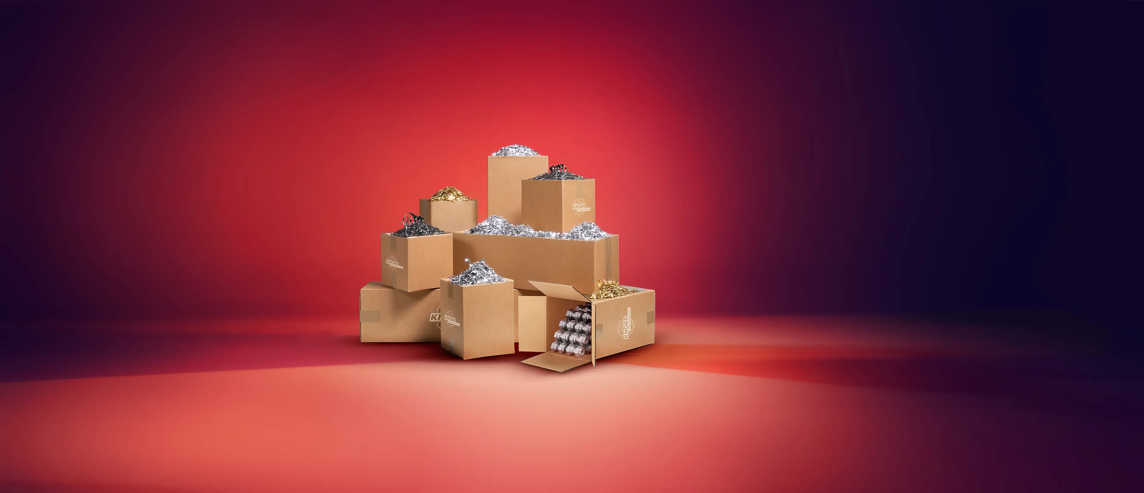 Eine Pyramide offener Pappschachteln, gefüllt mit Hershey's Kisses-Bonbons, steht auf einem Hintergrund mit rotem und lila Farbverlauf. Einige Bonbons quellen vor den Schachteln hervor.